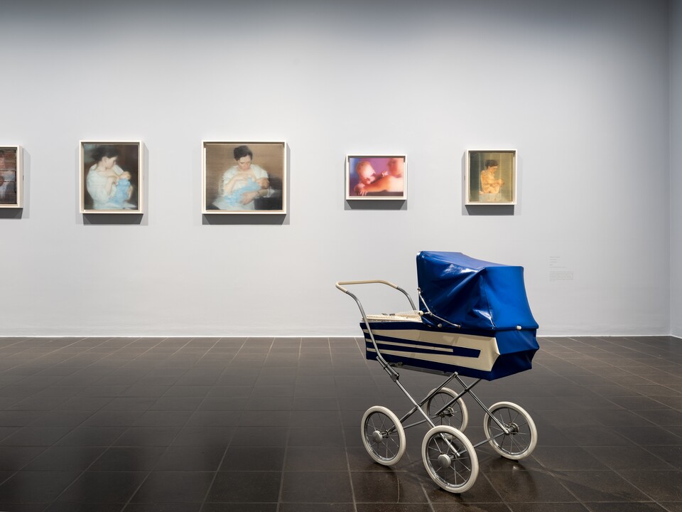 Ausstellungsansicht ISA MONA LISA: Gemälde der Serie S. mit Kind, 1995 von Gerhard Richter (*1932), © Gerhard Richter 2024 (28102024) und das Objekt Vogelfalle, 2001 von Andreas Slominski (*1959)